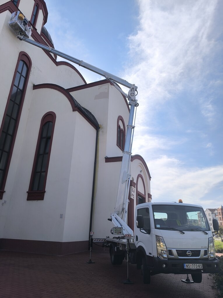 Kamion sa podignutom strelom ispred crkve